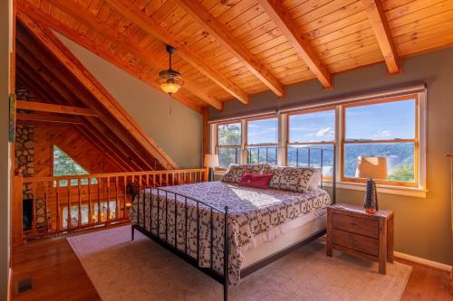 ブーンにあるWhispering Ridge Retreatのベッドと大きな窓のある寝室