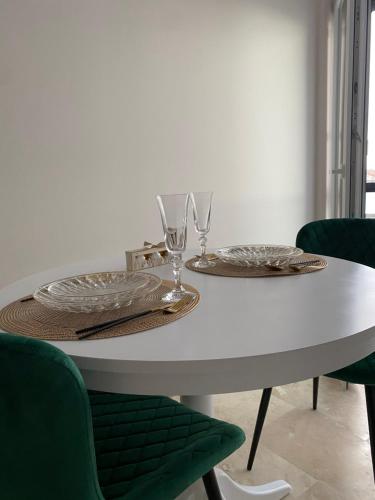 einem weißen Tisch mit zwei Tellern und Gläsern darauf in der Unterkunft Apartamente cu un dormitor in Timişoara