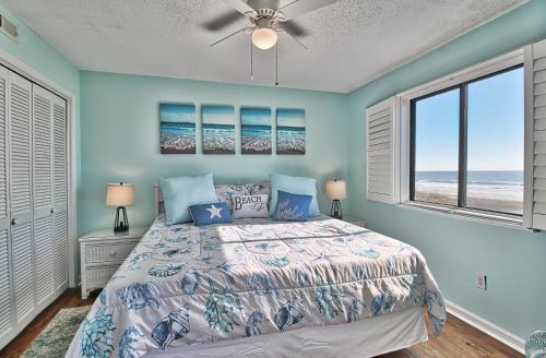 een slaapkamer met een bed en 2 ramen bij Direct Ocean Front 3BR/2BA Dog Friendly **OCEANFRONT** in Myrtle Beach