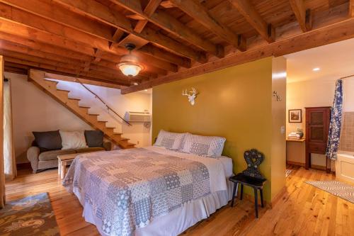 a bedroom with a bed and a staircase at Knotty Pine in West Jefferson