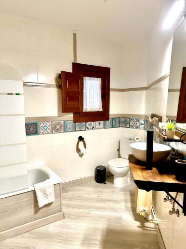 a bathroom with a sink and a toilet and a tub at Apartamentos Vista Veleta in Capileira