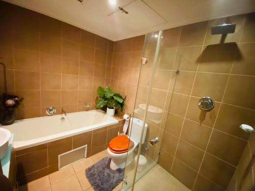 a bathroom with a tub and a toilet and a shower at The Waves, 806 Quayside Point Waterfront in Durban