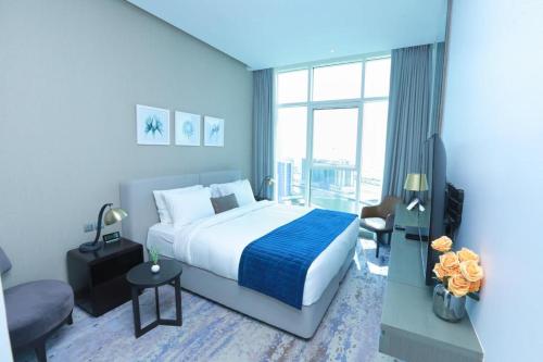 a bedroom with a large bed and a large window at DAMAC MAISON PRIVE in Dubai