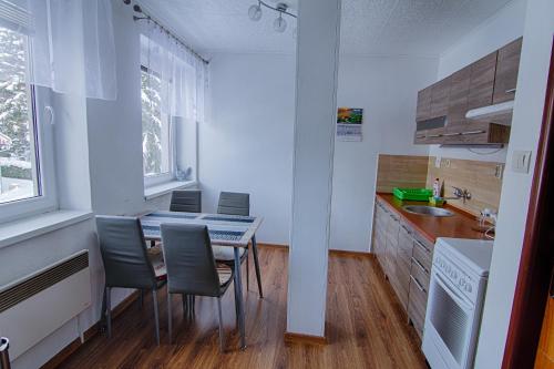 uma cozinha com mesa e cadeiras num quarto em Apartmán Iveta em Rokytnice nad Jizerou