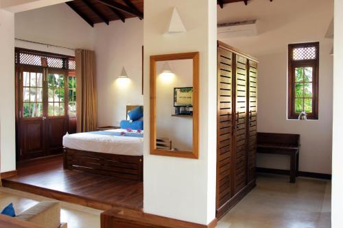 a bedroom with a bed and a mirror at Sky and Sand Guesthouse in Beruwala