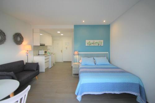 um pequeno quarto com uma cama e um sofá em CasaTuris Estudio vistas increíbles en Centro de Alicante A115 em Alicante