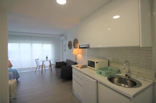 eine Küche mit einem Waschbecken und ein Wohnzimmer in der Unterkunft CasaTuris Estudio vistas increíbles en Centro de Alicante A115 in Alicante