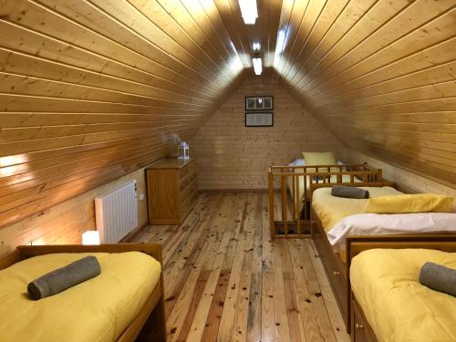 a room with three beds in a wooden cabin at Sierra Nevada Cabaña de madera in Sierra Nevada