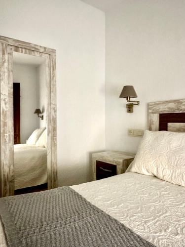 a bedroom with two beds and a large mirror at Apartamentos Vista Veleta in Capileira