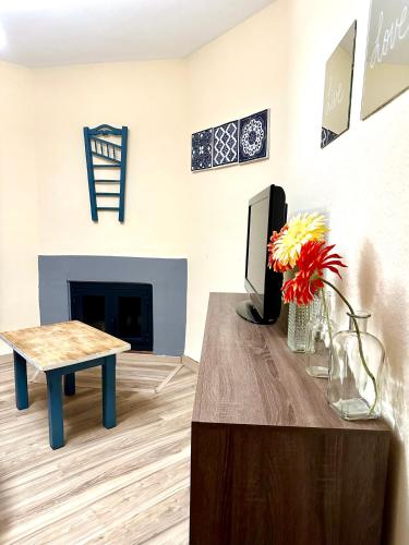a living room with a tv and a table at Apartamentos Vista Veleta in Capileira