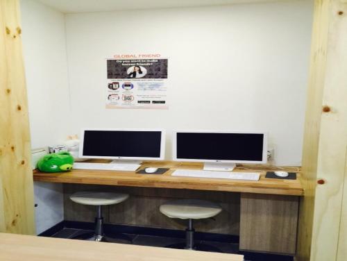 a desk with two monitors and a keyboard and mouse at 24 Guesthouse Myeongdong Avenue in Seoul