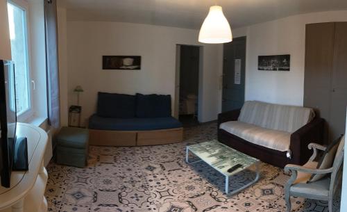 ein Wohnzimmer mit einem Sofa und einem Stuhl in der Unterkunft "La Clé dès Champs"-Meublé de Tourisme 3 étoiles -Résidence "Les Logis de Béziers"-Garage optionnel-Cœur de ville-Plages à 16km ! in Béziers