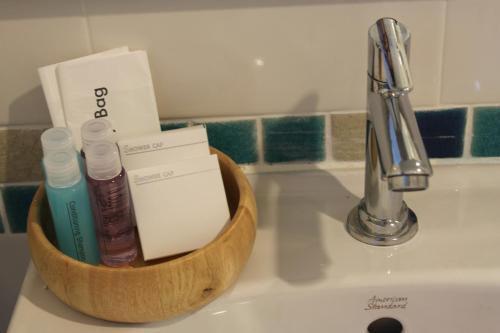 a container of toothpaste and toothbrushes on a sink at V-Ocean Palace in Hat Yai