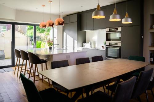 una cocina con una gran mesa de madera y sillas en Luxurious 4 bedroom townhouse in Buxton en Buxton