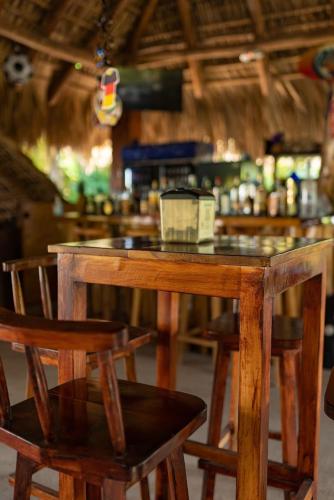 a wooden table with two chairs and a bar at The Beach Break Hotel El Zonte in El Zonte