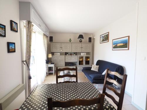 un salon avec une table et un canapé bleu dans l'établissement T2 Arcachon, Jardin Terrasse, Proche Plage, Parking Privé - FR-1-474-75, à Arcachon