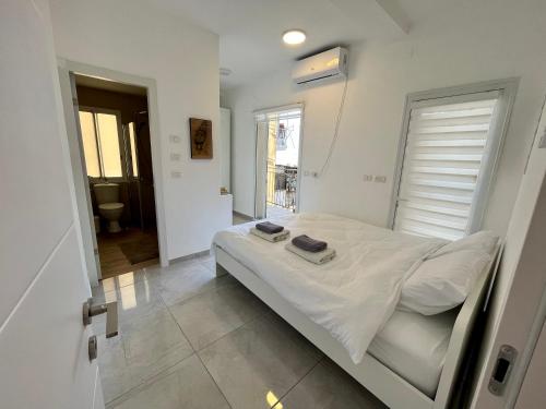 ein Schlafzimmer mit einem weißen Bett mit zwei Handtüchern darauf in der Unterkunft A cozy 2bdrm home in Wadi-Nisnas Haifa in Haifa