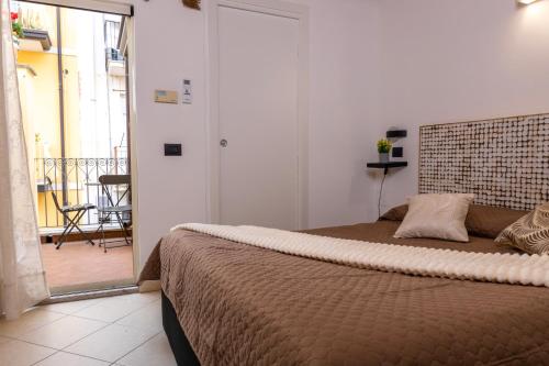een slaapkamer met een groot bed en een balkon bij Amunì Taormina in Taormina