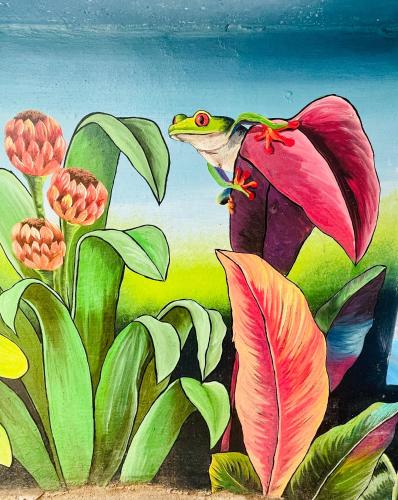 a painting of a frog sitting on a flower at The Beach Break Hotel El Zonte in El Zonte