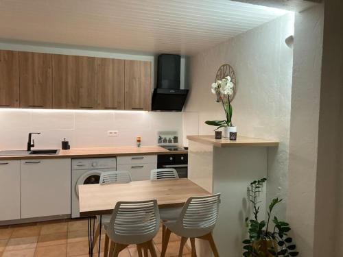 a kitchen with a table and chairs in a kitchen at Appartement Type 2 de 40m2 avec spa privatif in Ventabren