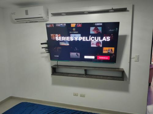 a flat screen tv hanging on a wall at Cómodo dpto full equipo 2 hab, seguridad y parqueo privado in Guayaquil