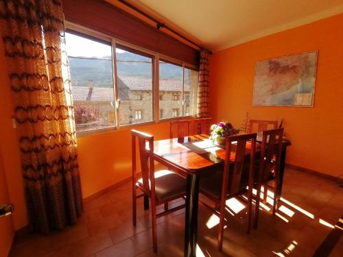 comedor con mesa, sillas y ventana en LA CARA NORD , ALOJAMIENTO TURISTICO ,SALDES, A LOS PIES DEL PEDRAFORCA, apartamento, en Saldes