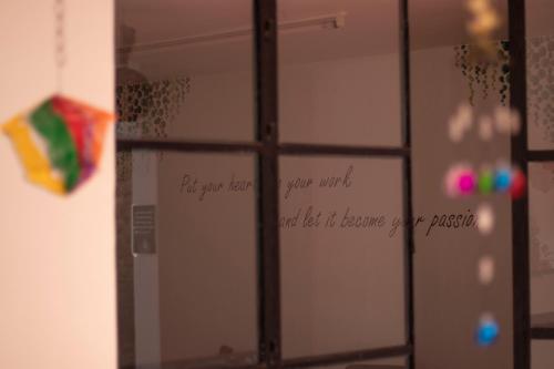 a mirror in a bathroom with a window with writing on it at Leveli Coliving in Guadalajara