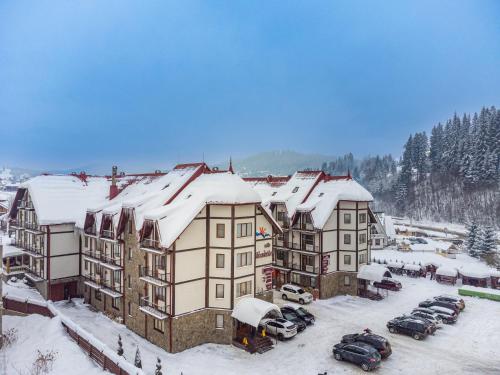 an apartment building with snow on top of it at Villa Nikoletta SPA in Bukovel