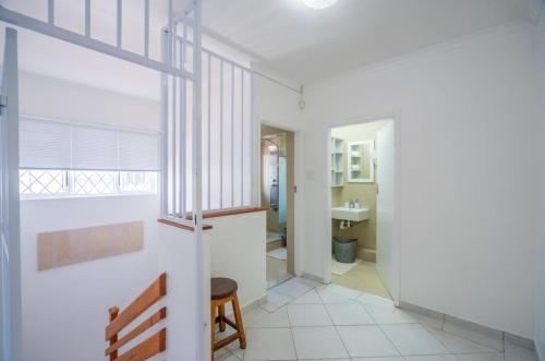 Habitación blanca con banco y baño en Durban Overport Halaal Accommodation "No Alcohol Strictly Halaal No Parties" Entire Luxury Apartment, 3 Bedrooms, 6 Sleeper, Self Catering "300m from Musjid Al Hilaal", en Durban