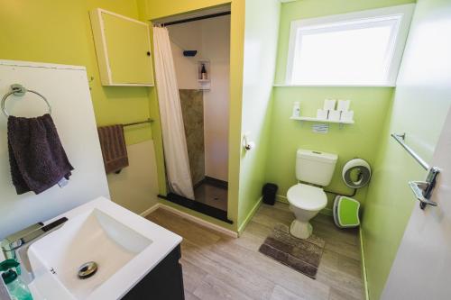 a bathroom with a sink and a toilet and a window at Cliff Top Cottage 
