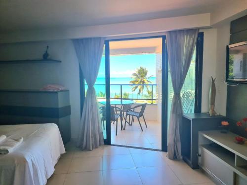 1 dormitorio con cama y vistas al océano en Flat Tabatinga Nord, vista para o mar en Conde