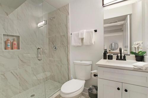 La salle de bains est pourvue d'une douche, de toilettes et d'un lavabo. dans l'établissement Urban Chic 1BR Apt in West Loop with in-unit Laundry - Aberdeen G, à Chicago
