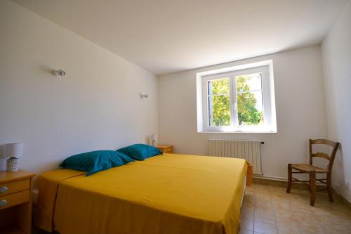 een slaapkamer met een geel bed en een raam bij Eco-gîte Le Batut 