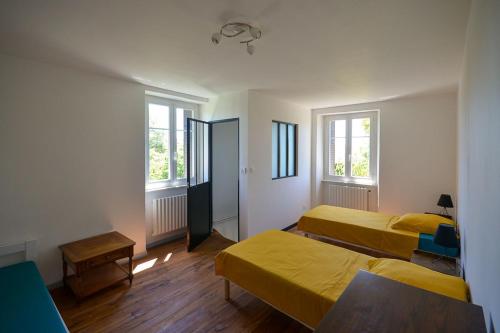 een kamer met 2 bedden en 2 ramen bij Eco-gîte Le Batut 