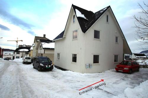 ハーシュタにあるSentral leilighet med 3 soveromの雪の黒屋根白家