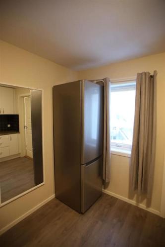 a stainless steel refrigerator in a room with a window at Sentral leilighet med 3 soverom in Harstad