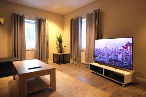 a living room with a large flat screen tv at Sentral leilighet med 3 soverom in Harstad
