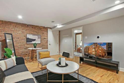 a living room with a couch and a brick wall at Perfect Stay - Modern 2BR Unit - Barry GB in Chicago