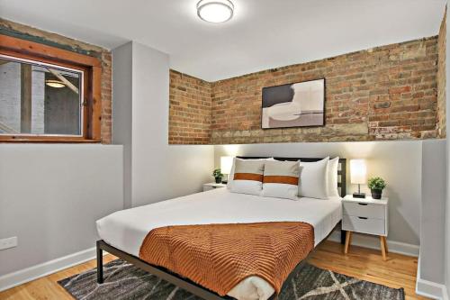 a bedroom with a large bed with a brick wall at Perfect Stay - Modern 2BR Unit - Barry GB in Chicago