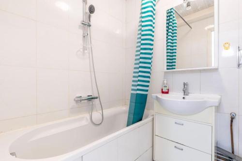 La salle de bains est pourvue d'une baignoire, d'un lavabo et d'une douche. dans l'établissement La Défense (15 min Champs-Élysées) - Whole flat, à Courbevoie