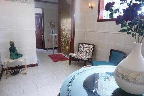 a room with a vase on a glass table with a vase at Happy Ours Guesthouse in Curepipe