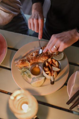 a person eating a plate of food on a table at DE VISSCHUUR in Paternoster