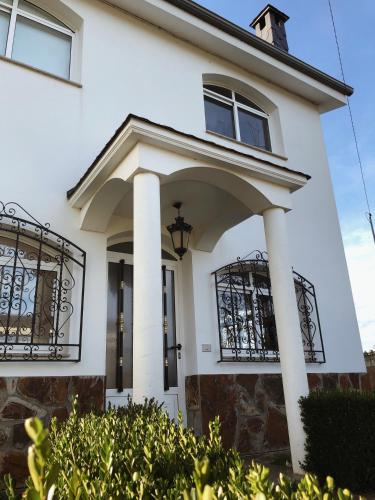 Casa blanca con columnas y balcón en Casa rural Raiceira, 