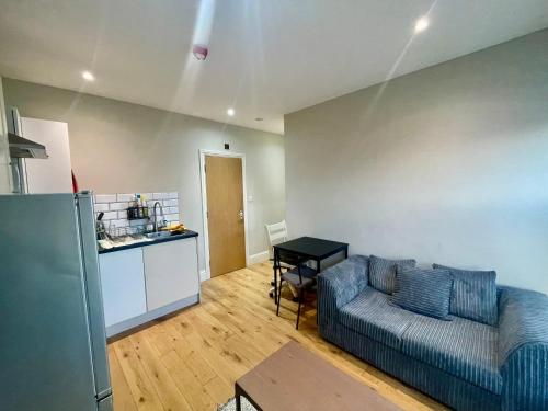 een woonkamer met een bank en een keuken bij Cosy 1 bedroom flat! in Londen