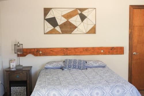 a bedroom with a bed and a picture on the wall at Quinta Monasterio in Valle de Guadalupe