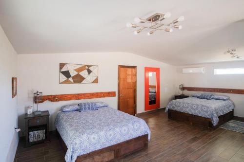 a bedroom with two beds and a nightstand and a bed sidx sidx sidx sidx at Quinta Monasterio in Valle de Guadalupe