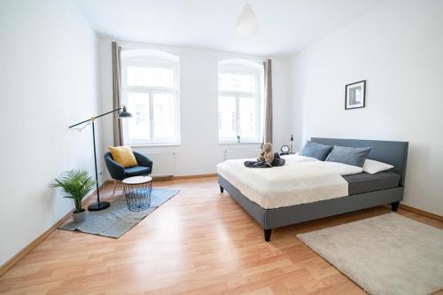 ein Schlafzimmer mit einem Bett und einem Stuhl darin in der Unterkunft FULL HOUSE Premium Apartments Magdeburg E3 in Magdeburg