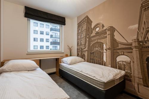 dwa łóżka w sypialni z malowidłem ściennym w obiekcie Luxury Copper Apartment II w Łodzi