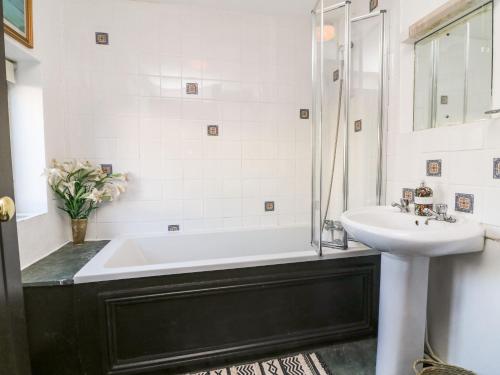 a bathroom with a tub and a sink at Bracken Cottage in Okehampton