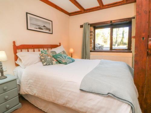 a bedroom with a white bed and a window at Threshers in Okehampton
